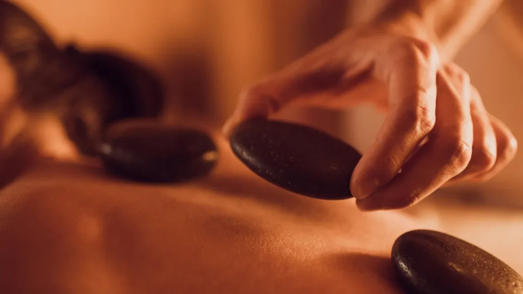 Hot stone massage in Istanbul with therapist placing warm basalt stones on back

