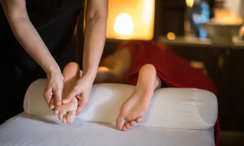 Therapist applying pressure on foot reflexology point