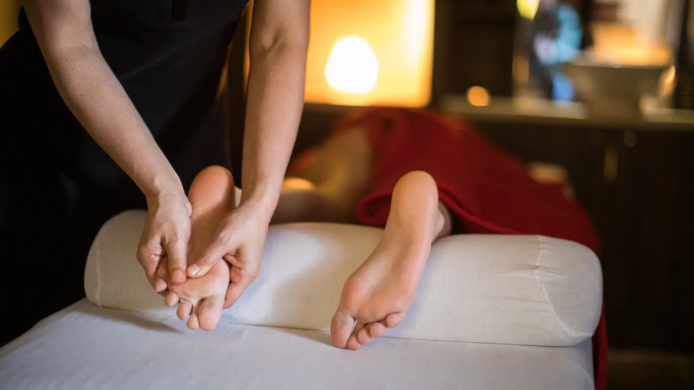 Therapist applying pressure on foot reflexology point