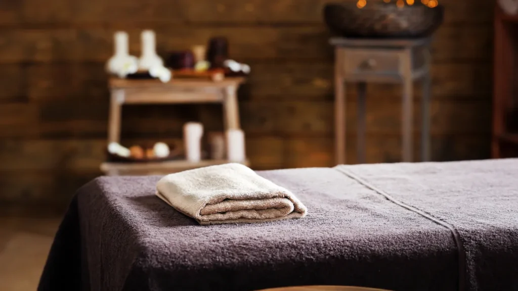 Close-up of lavender oil bottle on spa towel