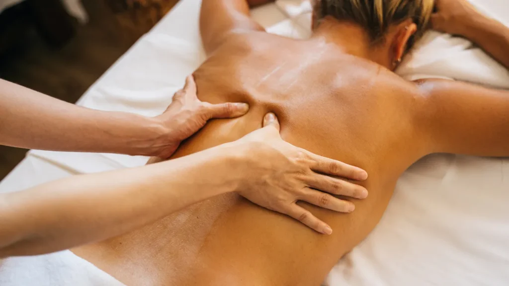 Client receiving hot stone therapy for spinal relief