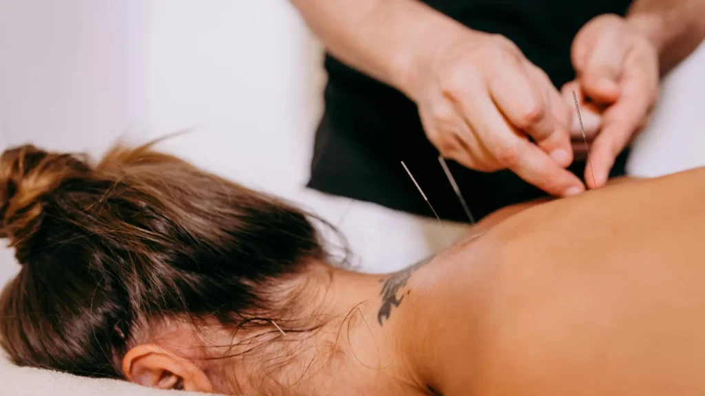 Massage therapist focusing on shoulder blade knots