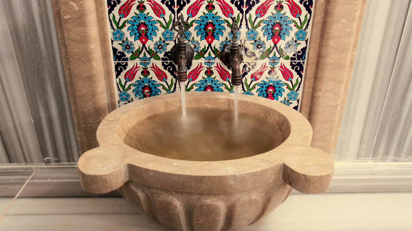 Client receiving traditional Turkish hammam treatment on marble stone