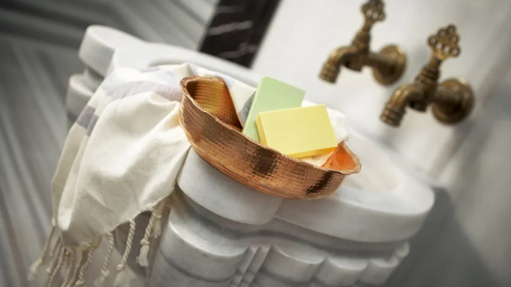 Kese glove and pestemal towel on marble platform.
